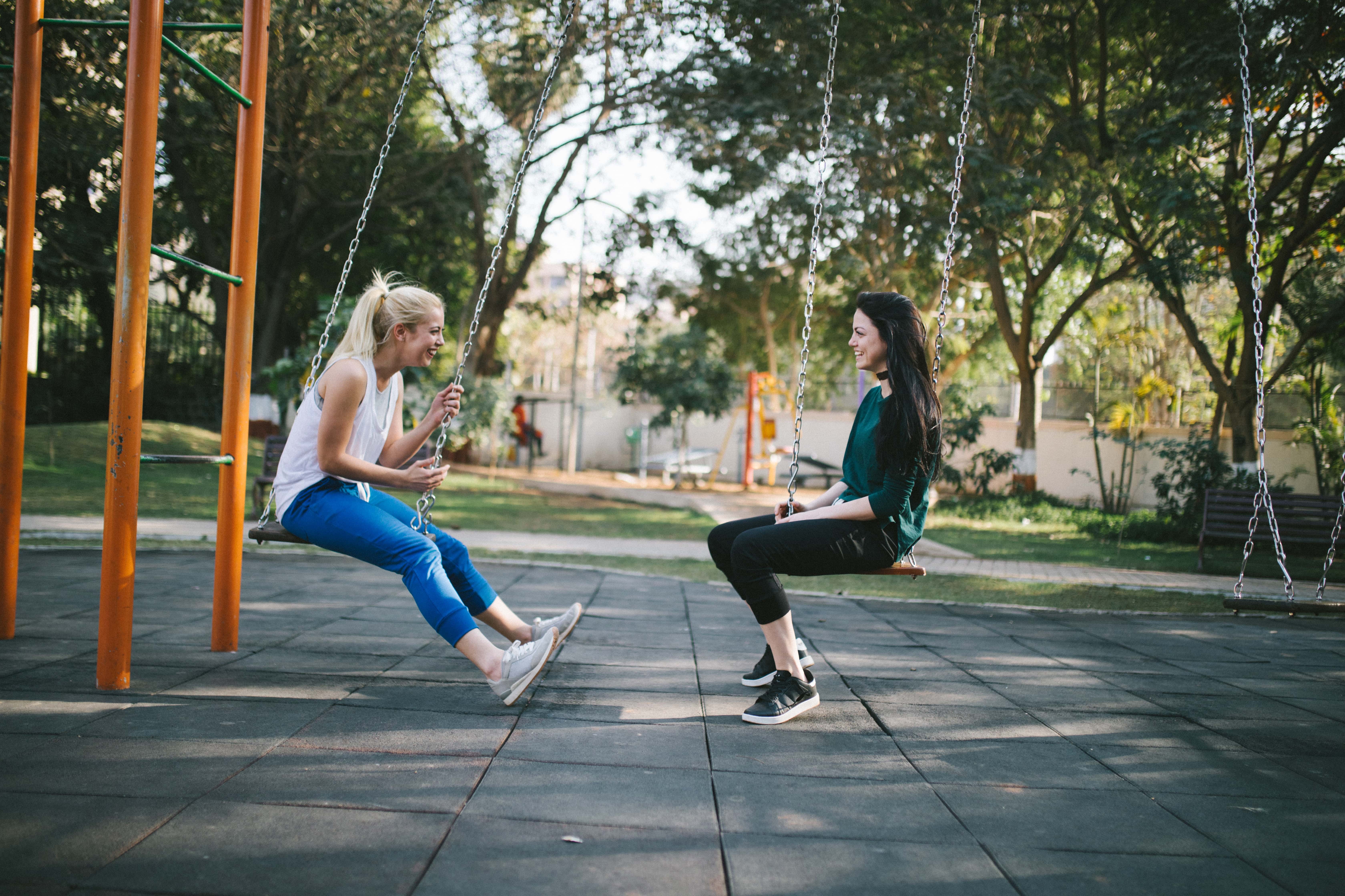 women talking on swings