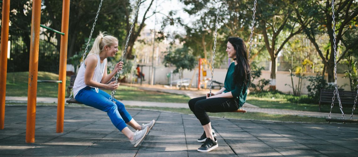 women talking on swings